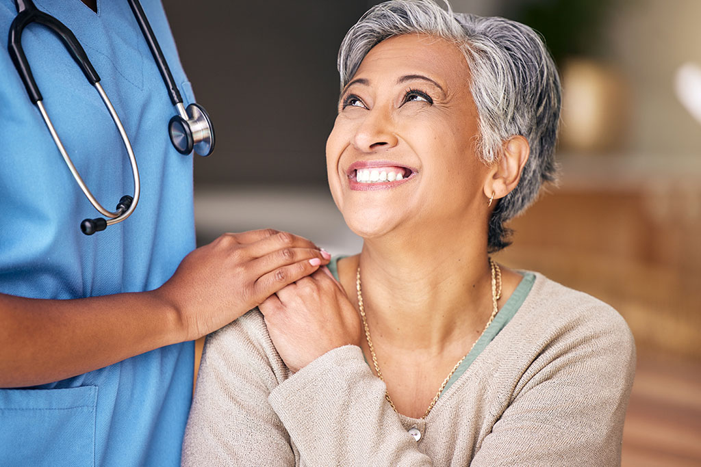 Nurse, senior woman and smile with comfort, holding hands