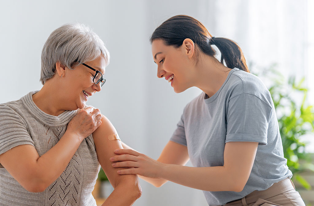 Senior woman after vaccination and her adult daughter at home. Virus protection. COVID-2019.