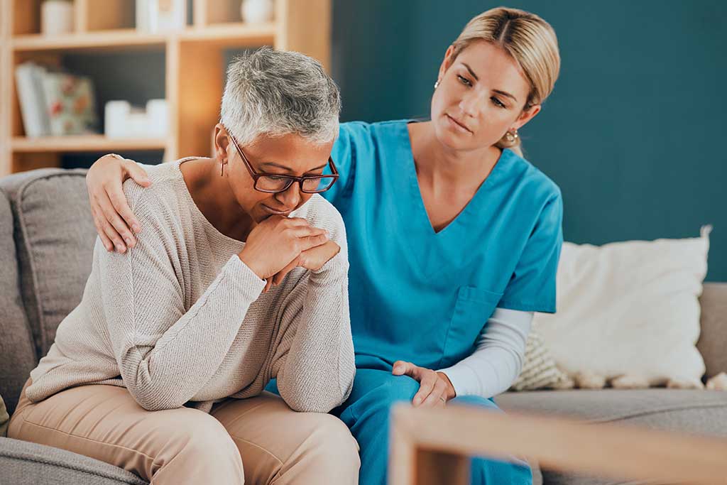 Bad news, support and nurse with a senior patient sitting on a sofa in her office at the hospital. Sad, upset and elderly woman with comfort from healthcare employee after medical diagnosis at clinic